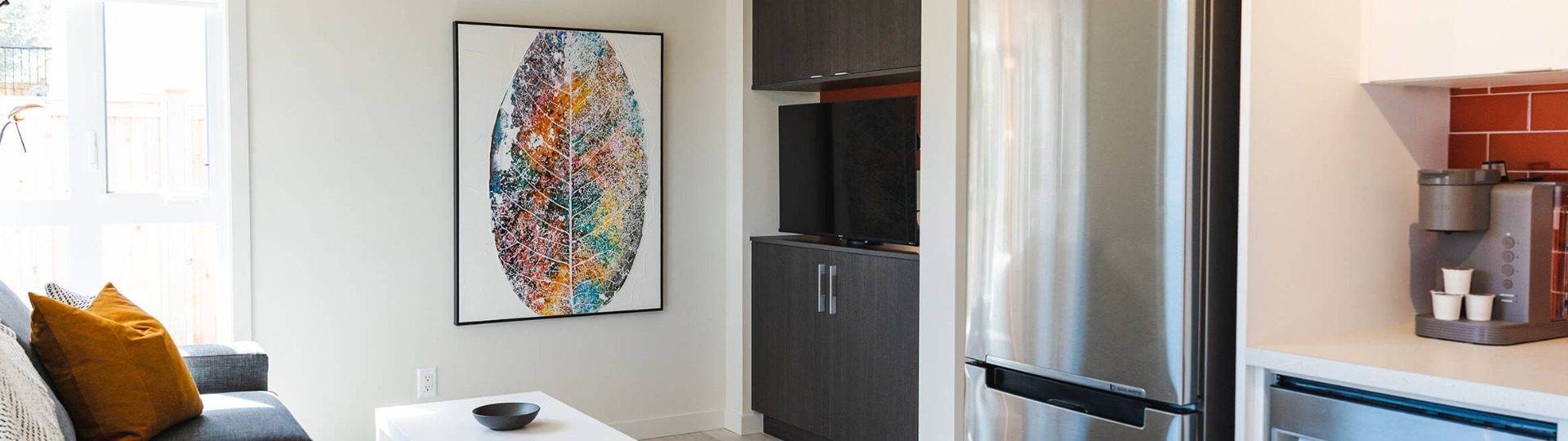 Interior of a modern suite with living area and brightly coloured painting of a leaf on the wall